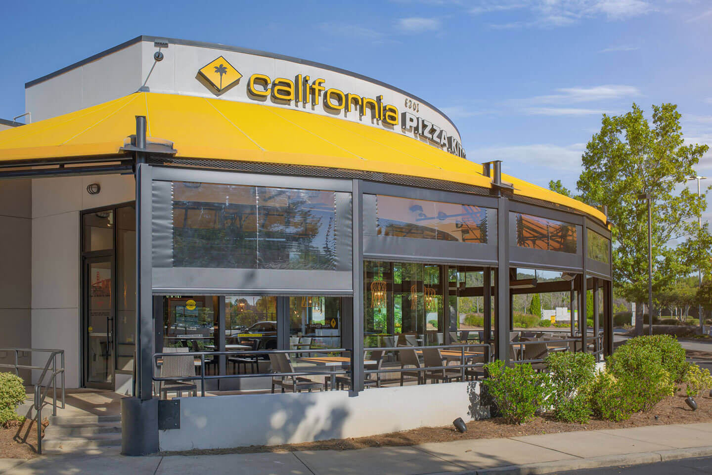 Commercial outdoor dining area with retractable shade and screen systems