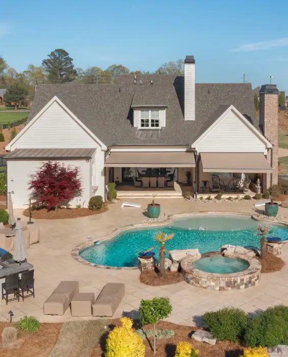 backyard of home with pool and retractable awnings