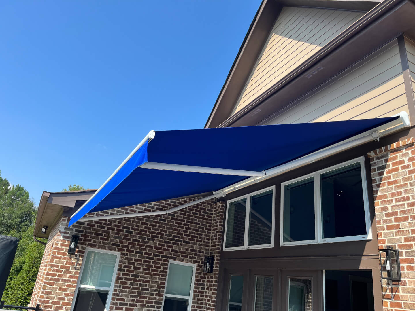 Blue retractable awning installed above residential windows