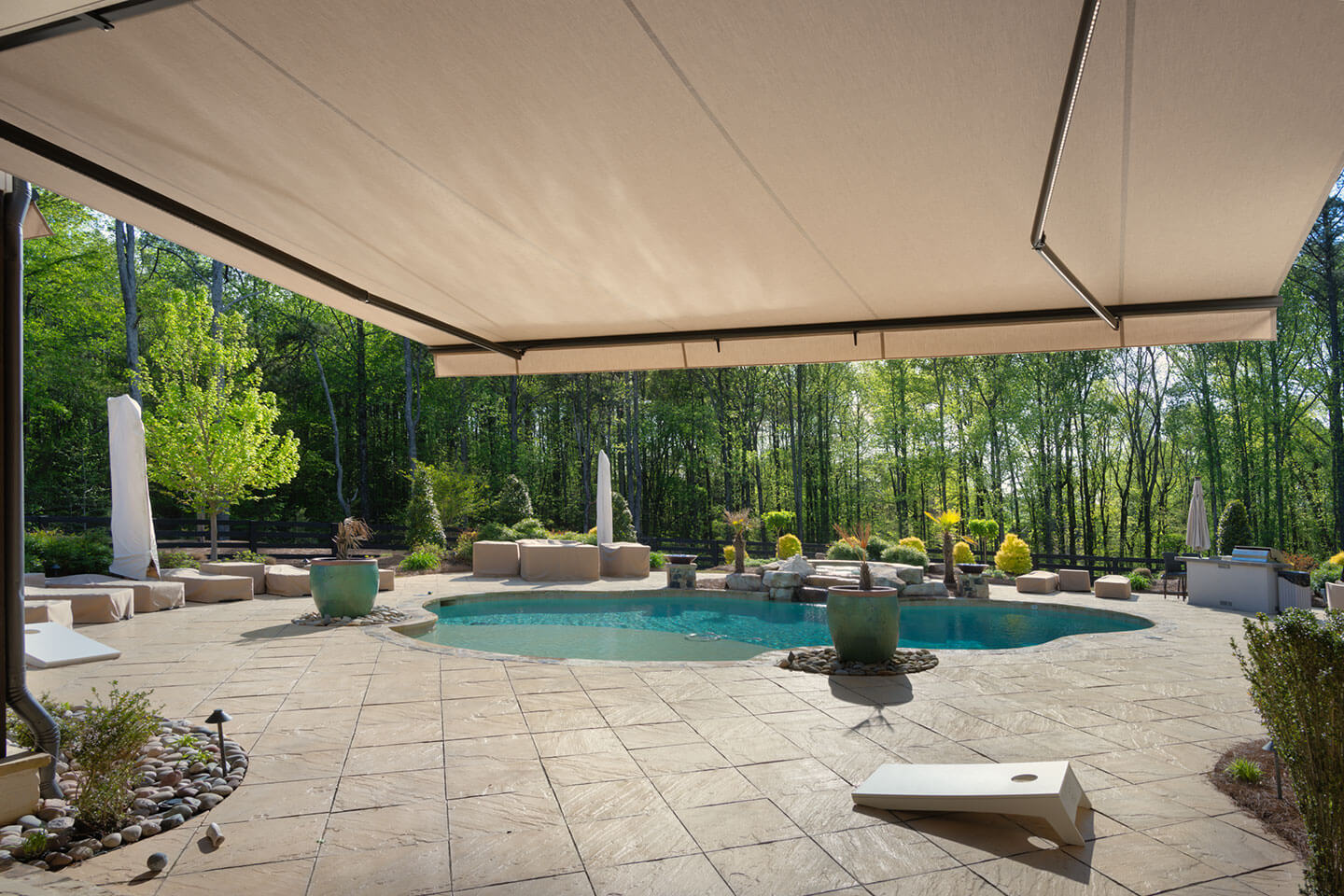Retractable awning providing shade beside a residential swimming pool