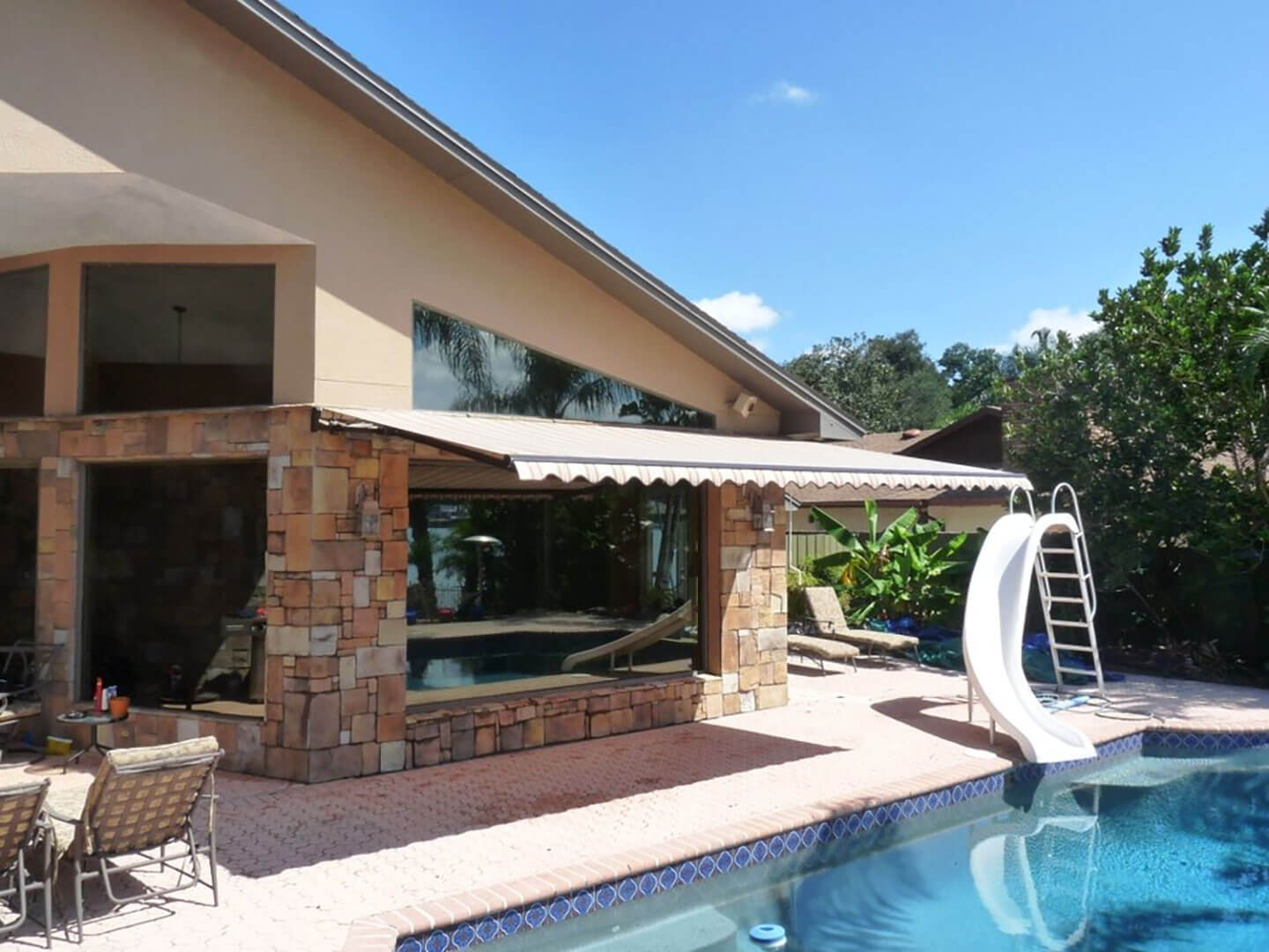 Retractable awning extended over a residential poolside patio
