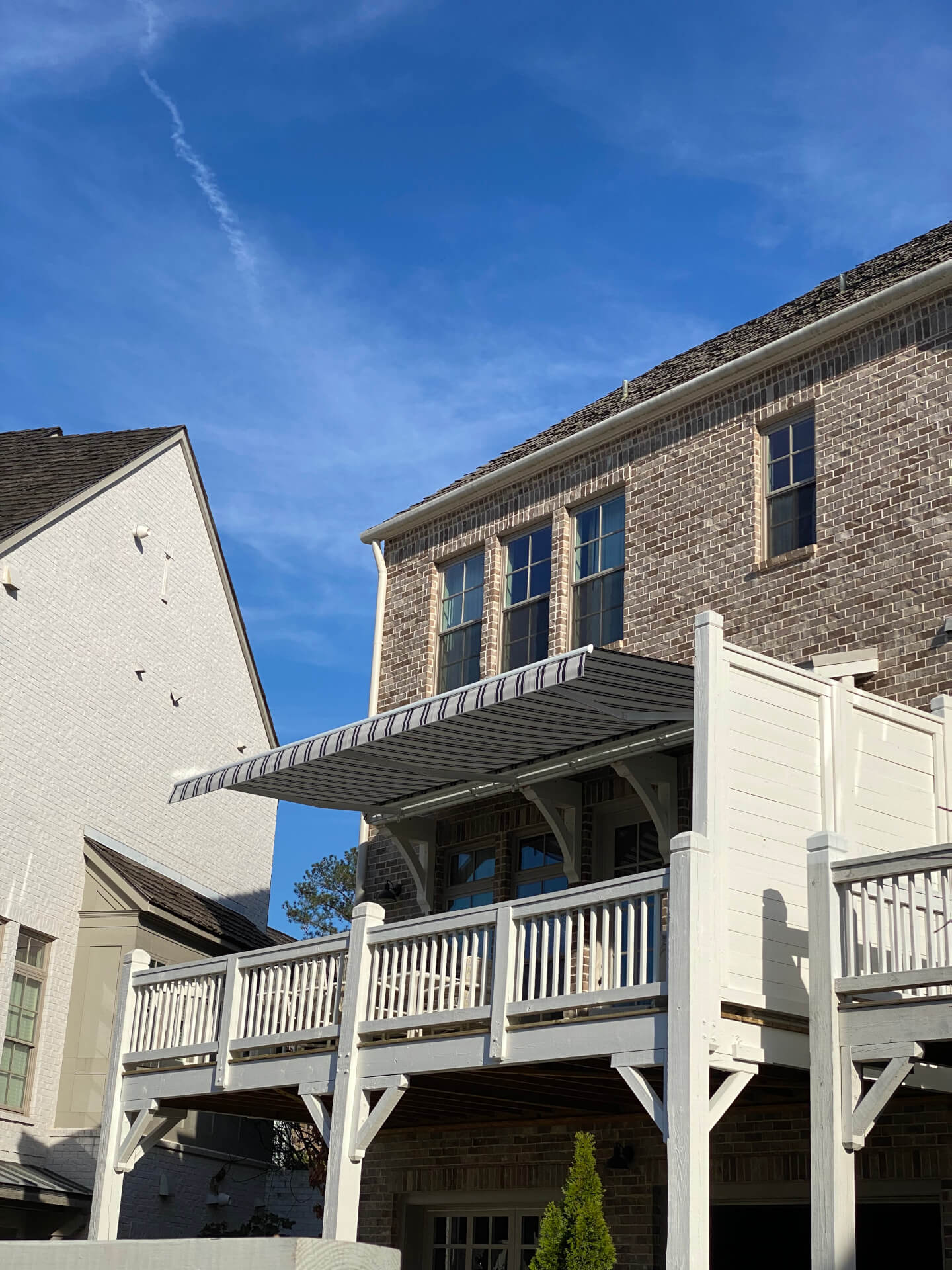 Retractable awning mounted above an elevated residential deck