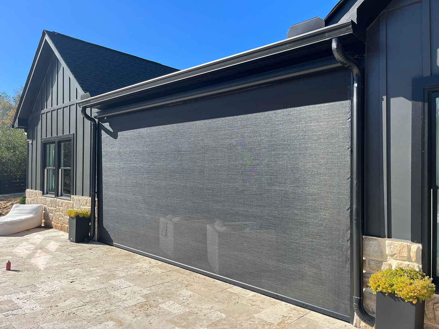 Exterior motorized solar shade mounted on a residential building