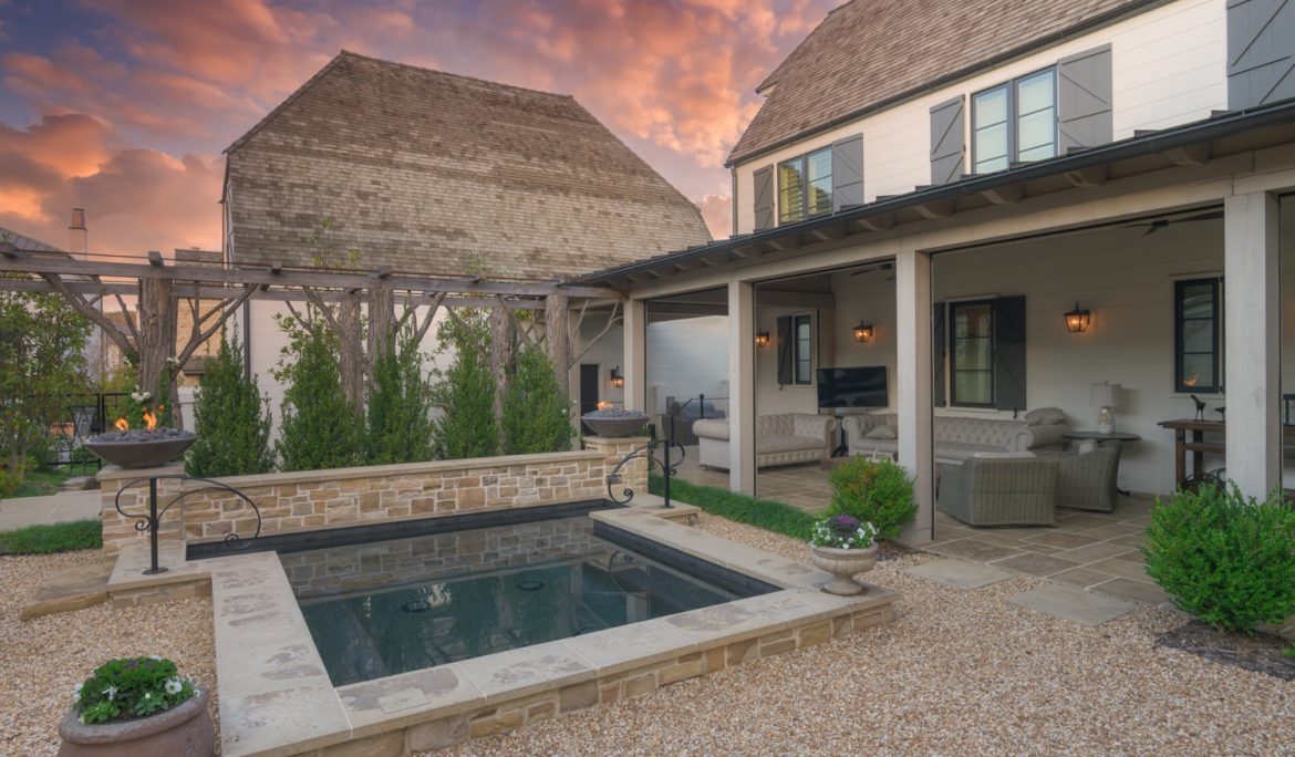 Beautiful outdoor porch with retractable screens overlooking pool at sunset