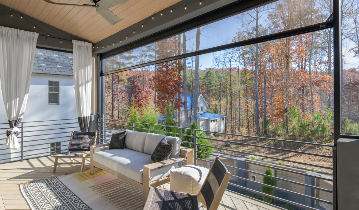 Back porch with retractable screens overlooking backyard during fall.