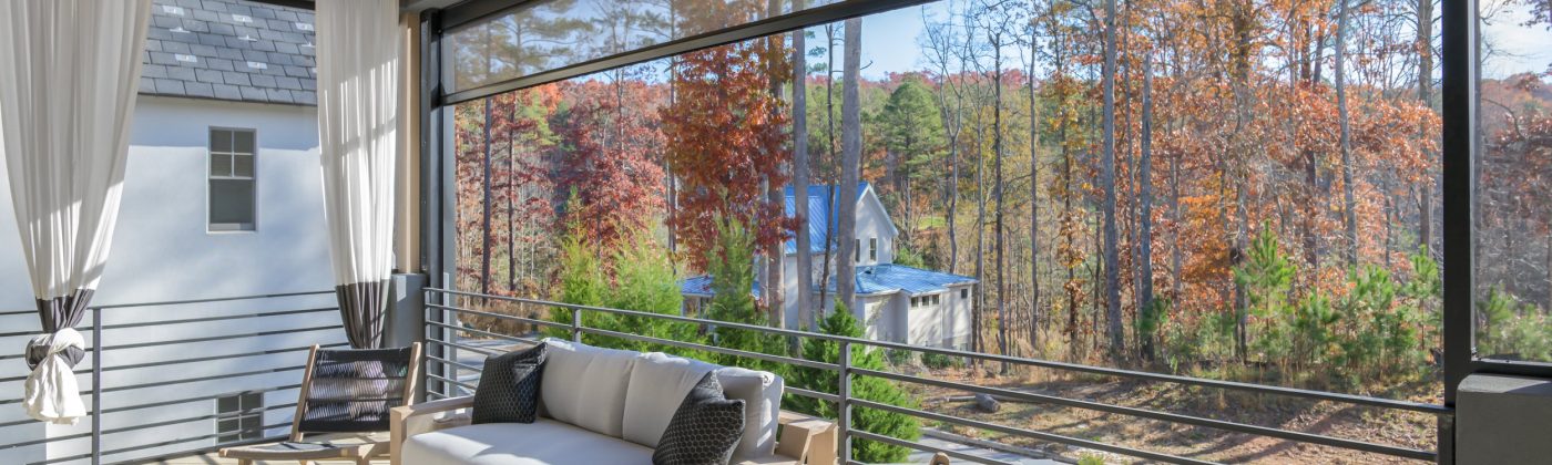 Back porch with retractable screens overlooking backyard during fall.